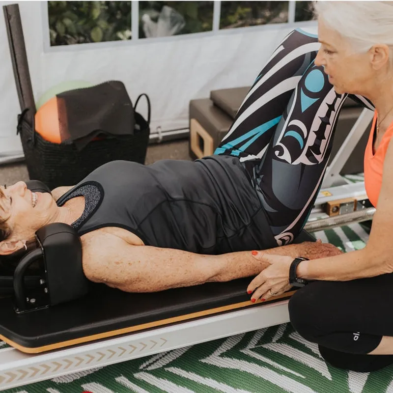 A client on the Cadillac working with two Momentum instructors