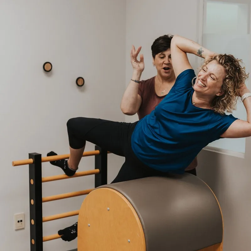 Clients training on arc barrels during a circuit-style session at Momentum Pilates