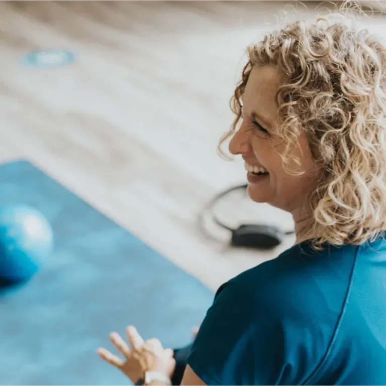 Peggy Cuthbert, founder of Momentum Pilates, guiding a client through a reformer exercise